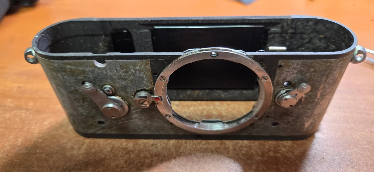 Leica M2 front before repair, with its top cover and exterior skin removed, exposing the body shell around the lens mount.